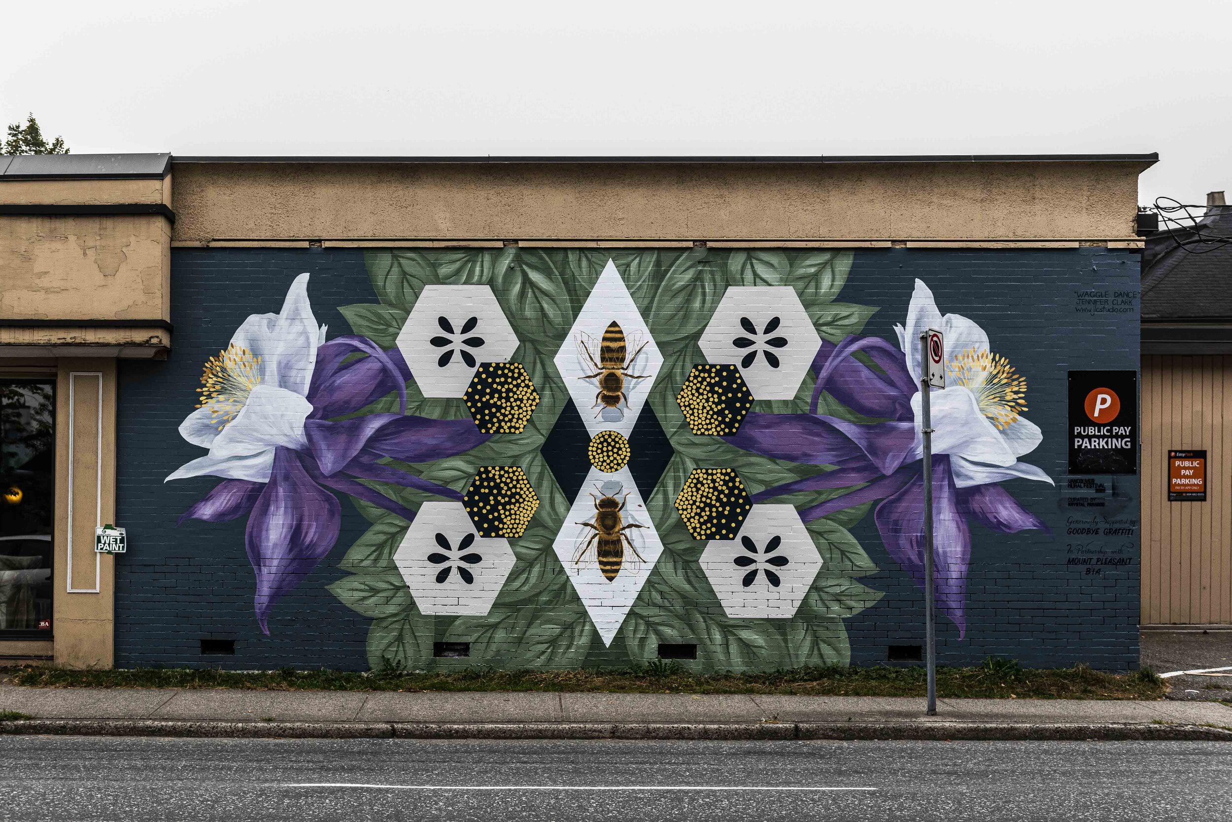 Symmetrical mural of two purple flowers, foliage, and bees.