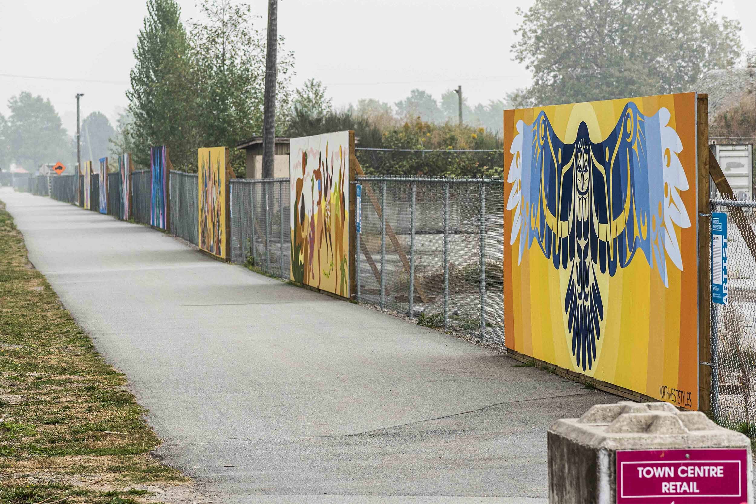 Plywood mural gallery of 8 murals in a row at River District, Vancouver