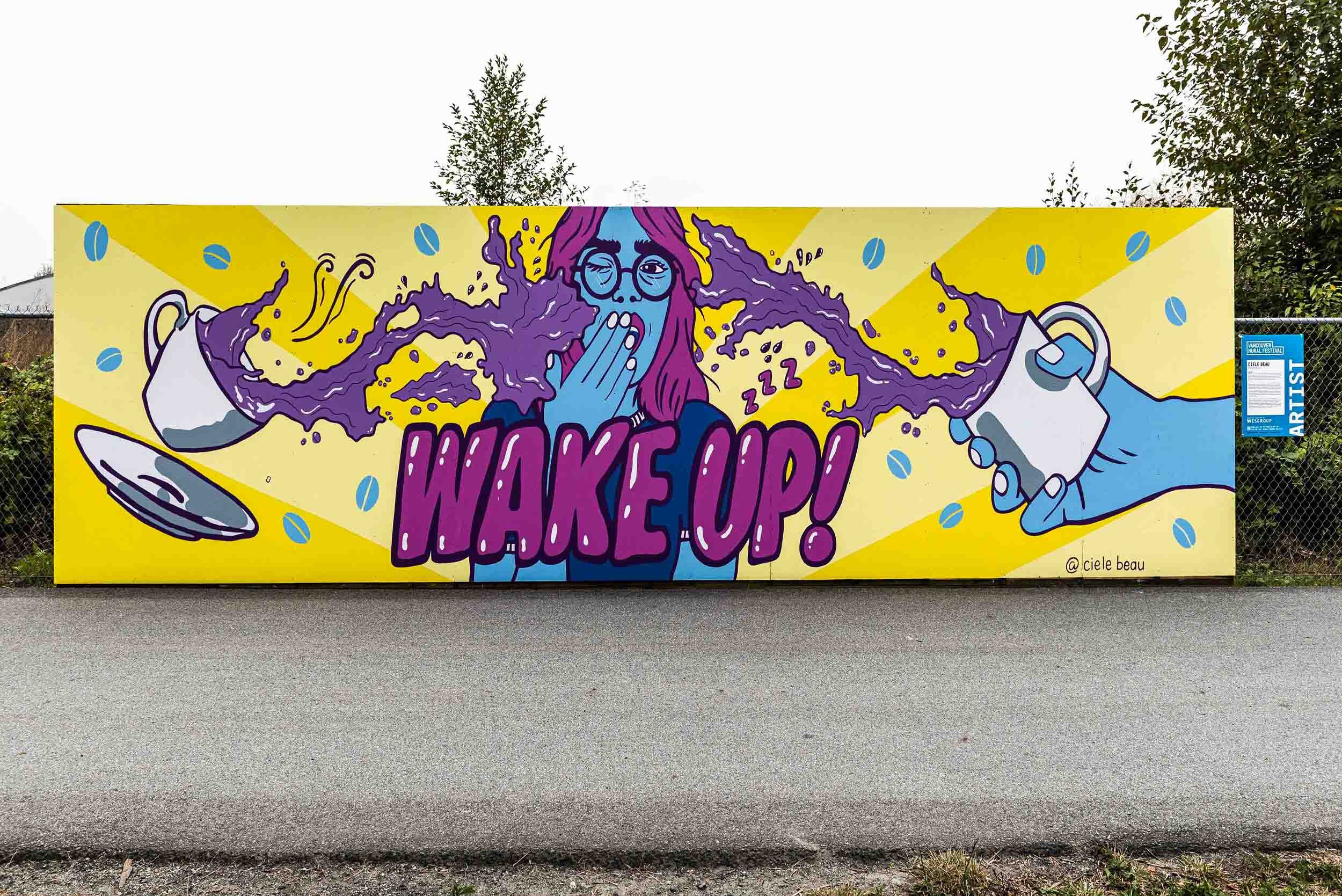 Artist Ciele Beau's yawning person with “wake up” typography in River District for Vancouver Mural Festival 2020